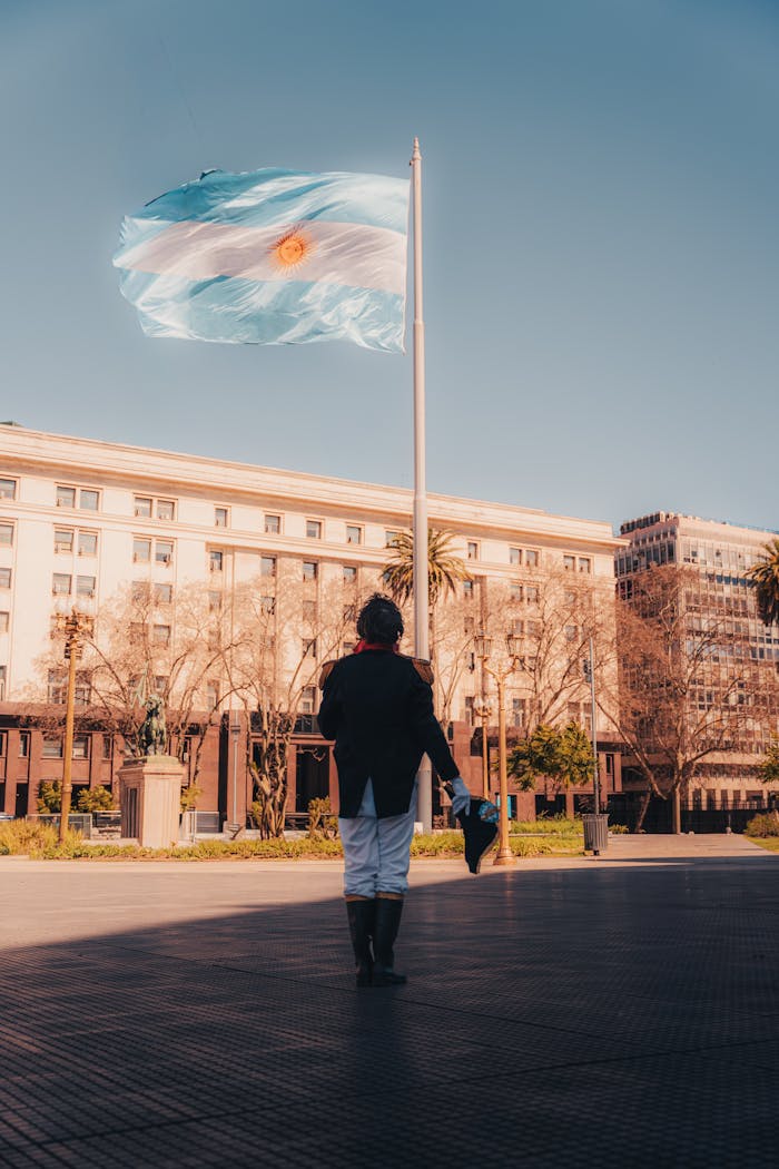 A historic soldier stands before the Argentine flag in Plaza de Mayo, Buenos Aires.
